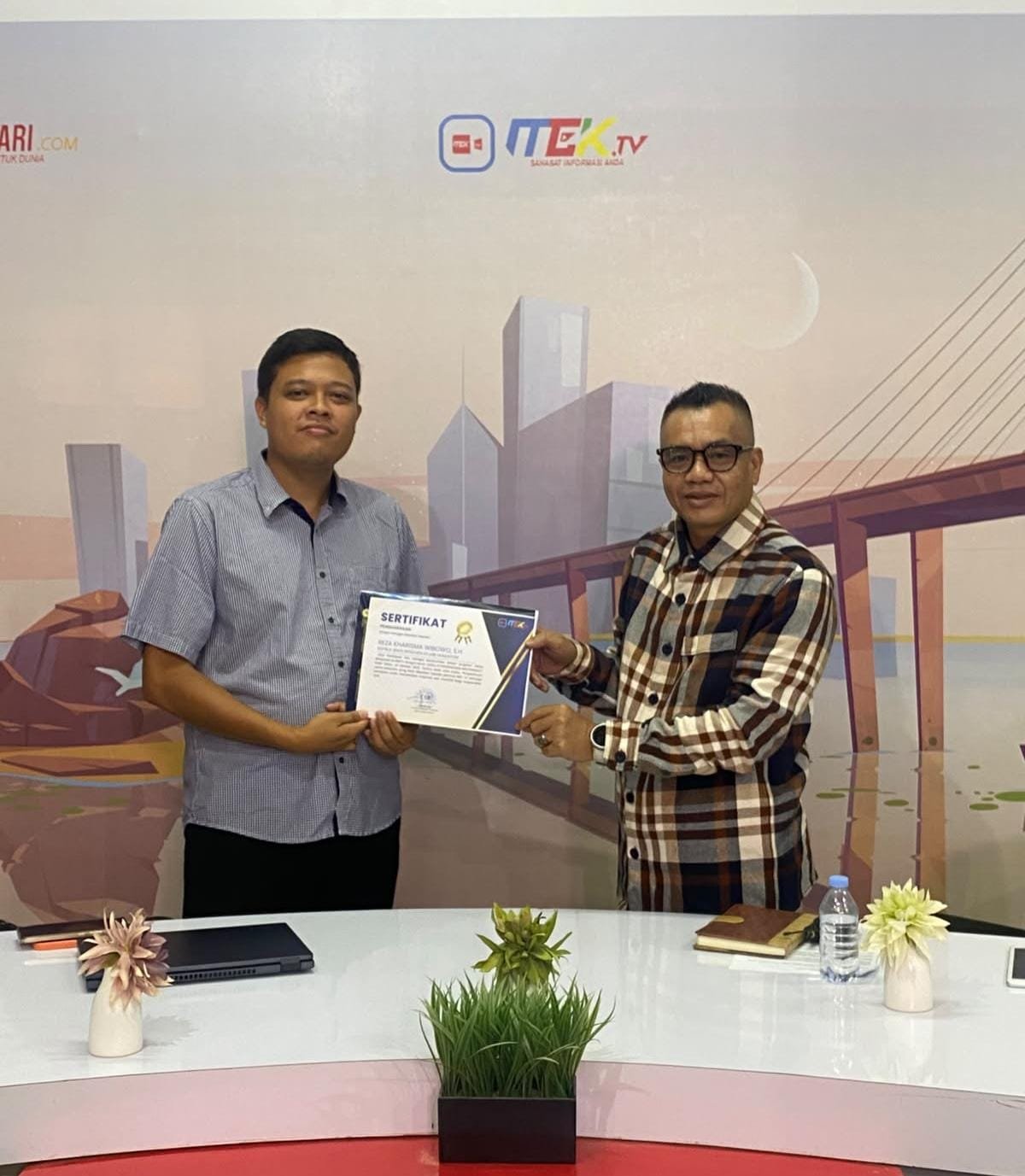 Direktur MEK TV, Jafrun, Menyerahkan Sertifikat Penghargaan kepada Kasi Intel Kejari Wakatobi, Reza Kharisma Wibowo, S.H, usai Live Bahas Bahaya Judol di Program, Jaksa Menjawab.
